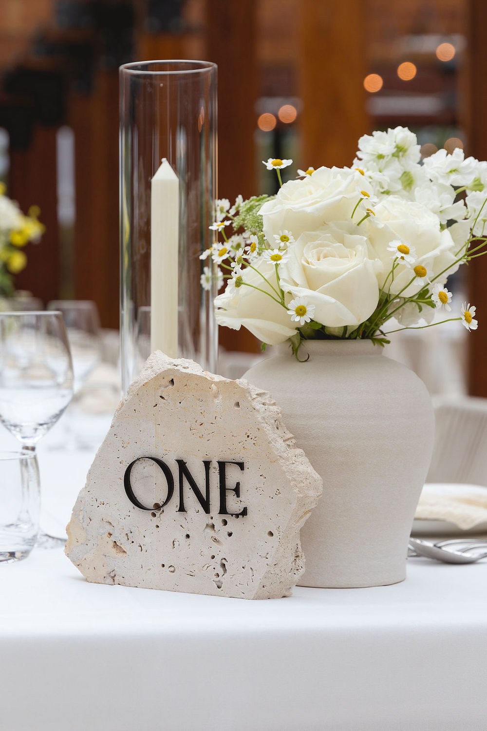 Stone table number with flowers and candle. Photographer Tash Mohring, wedding stylist The Modern Approach