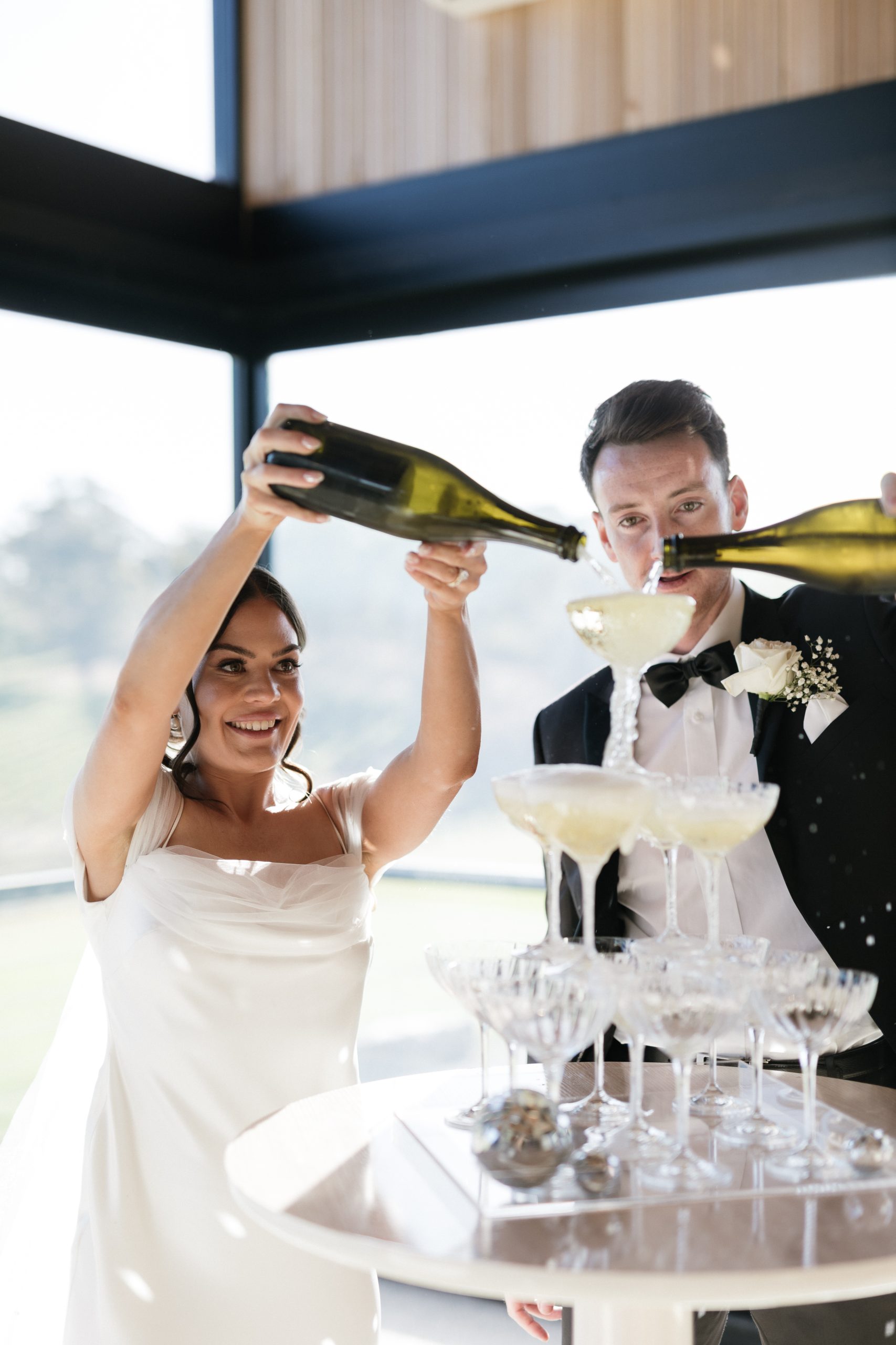 Bride and groom filling small champagne tower at longview vineyard