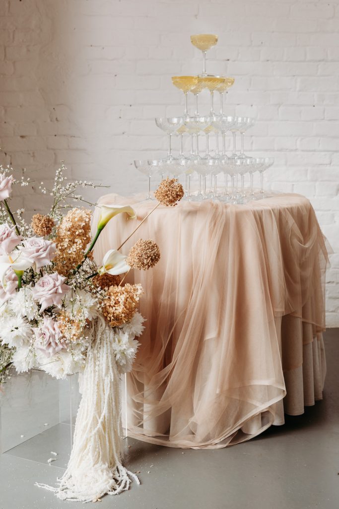 Champagne table with soft layering fabric and neutral rustic elegant modern flowers