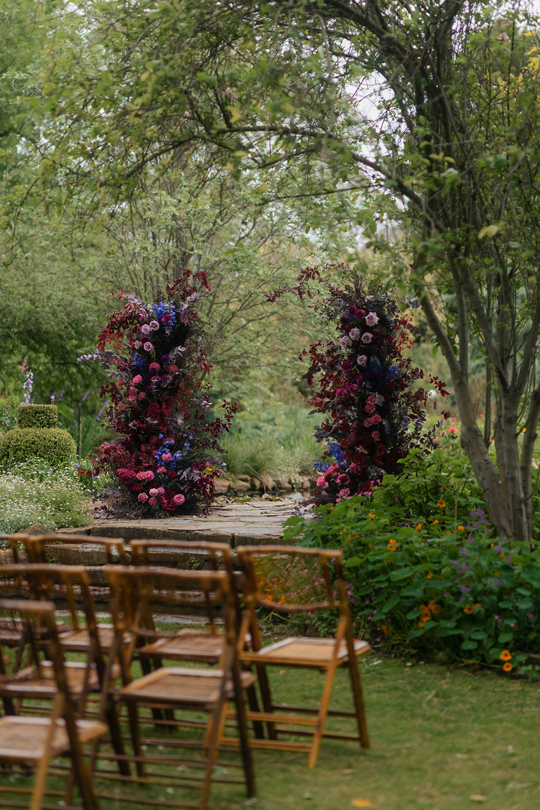 Etherial Botanica wedding arbor florals in dark purple and pink tones to suit the couples moody rustic elegance brief