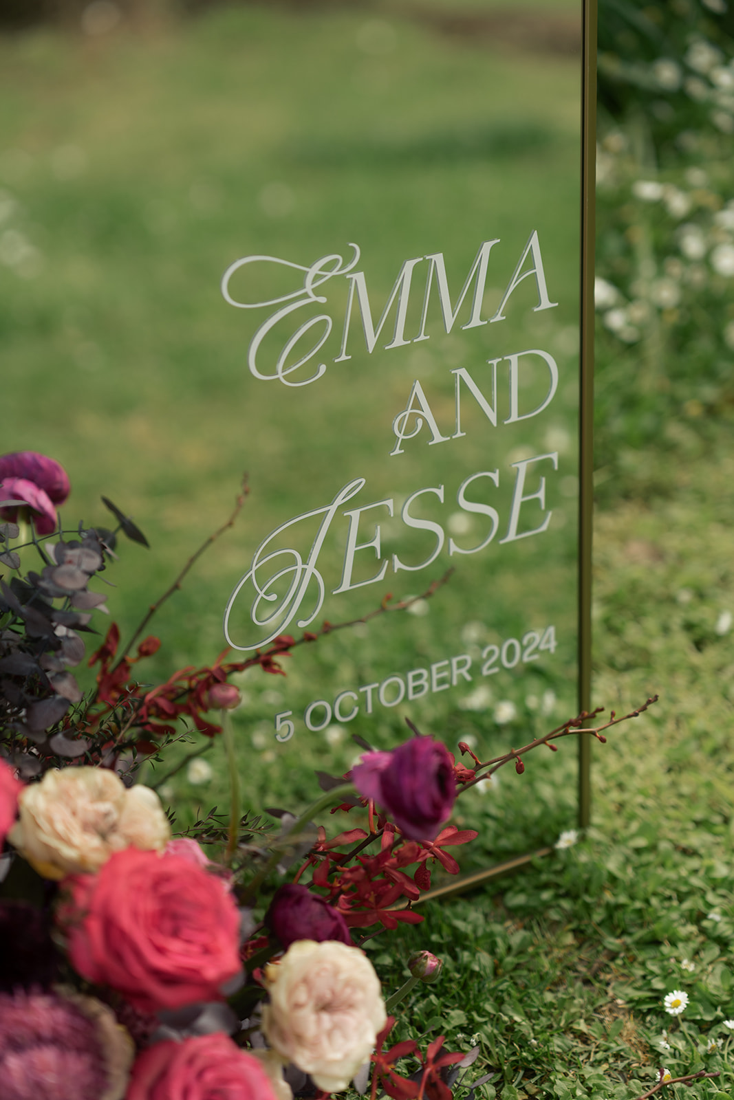 Mirror with couples names on it and flowers to create a moody rustic elegance