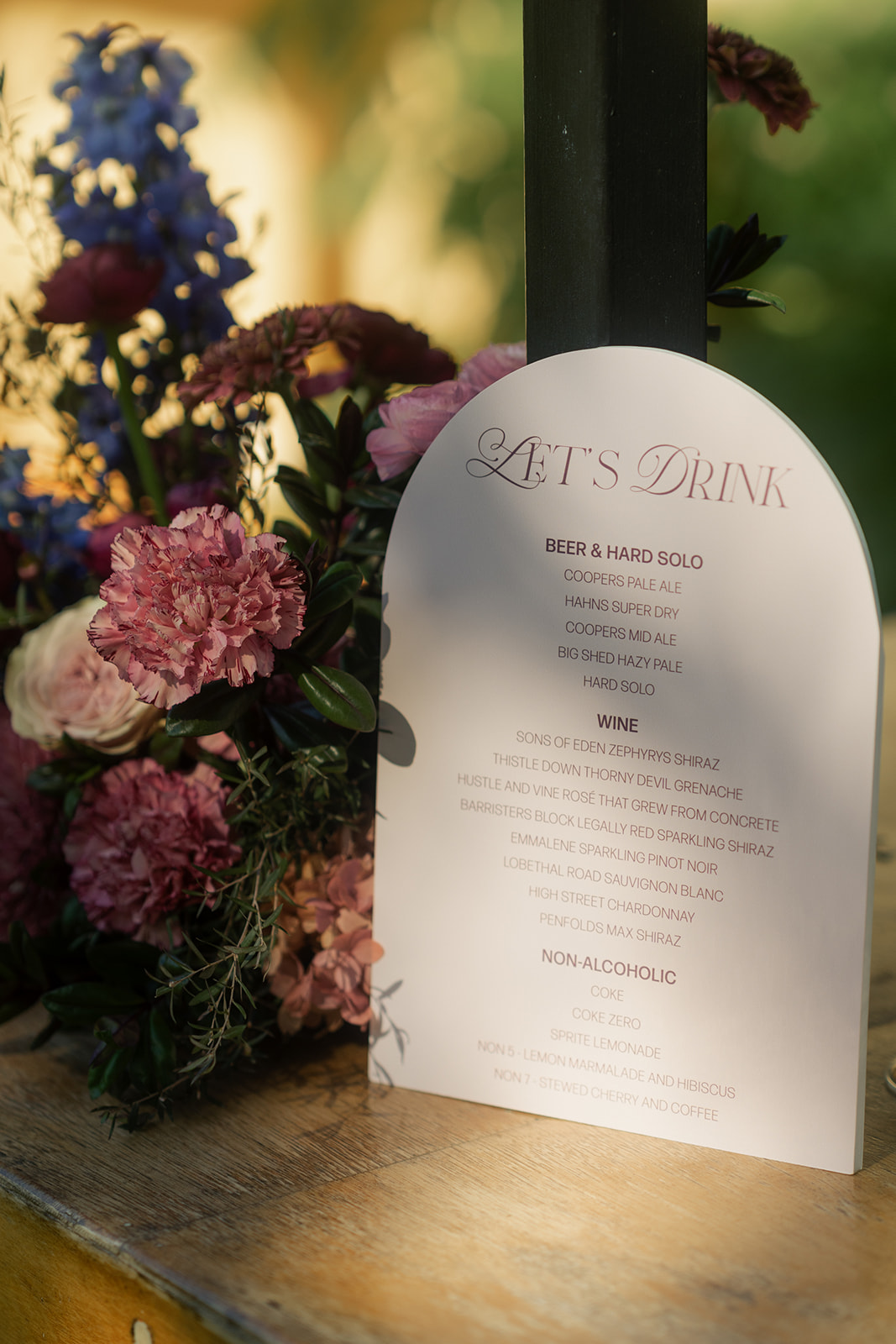 Flowers and beautiful text on drink signage in colour tones that suit moody rustic elegance