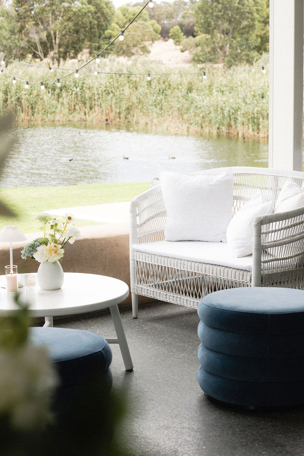 Photograph by Tash Mohring of white cane lounge and blue ottoman at LLoyd Brothers Winery, Mclaren Vale