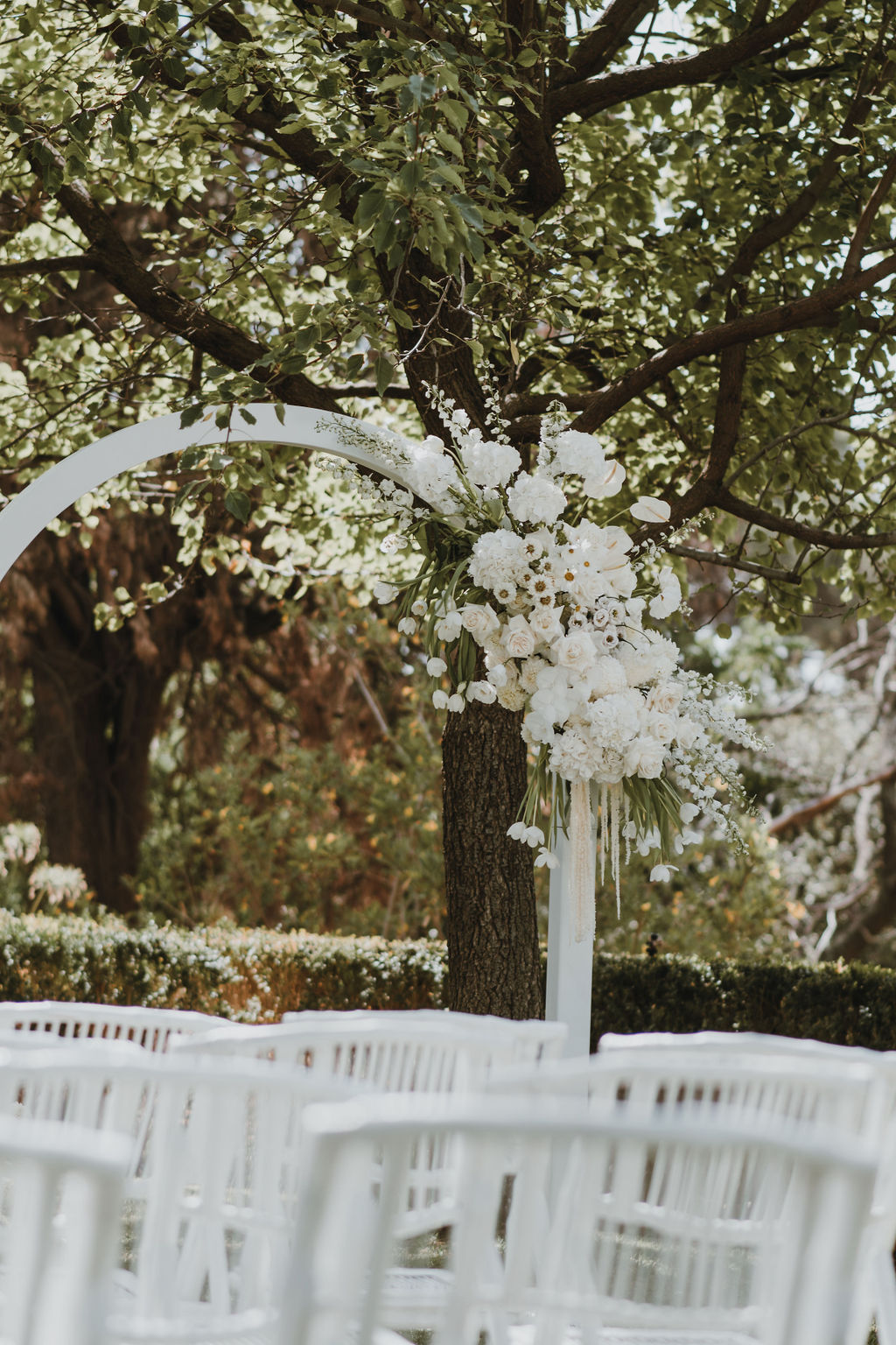 Maddy & Blake Classic Garden Party Wedding Arbor at white chairs at Marybank Estate