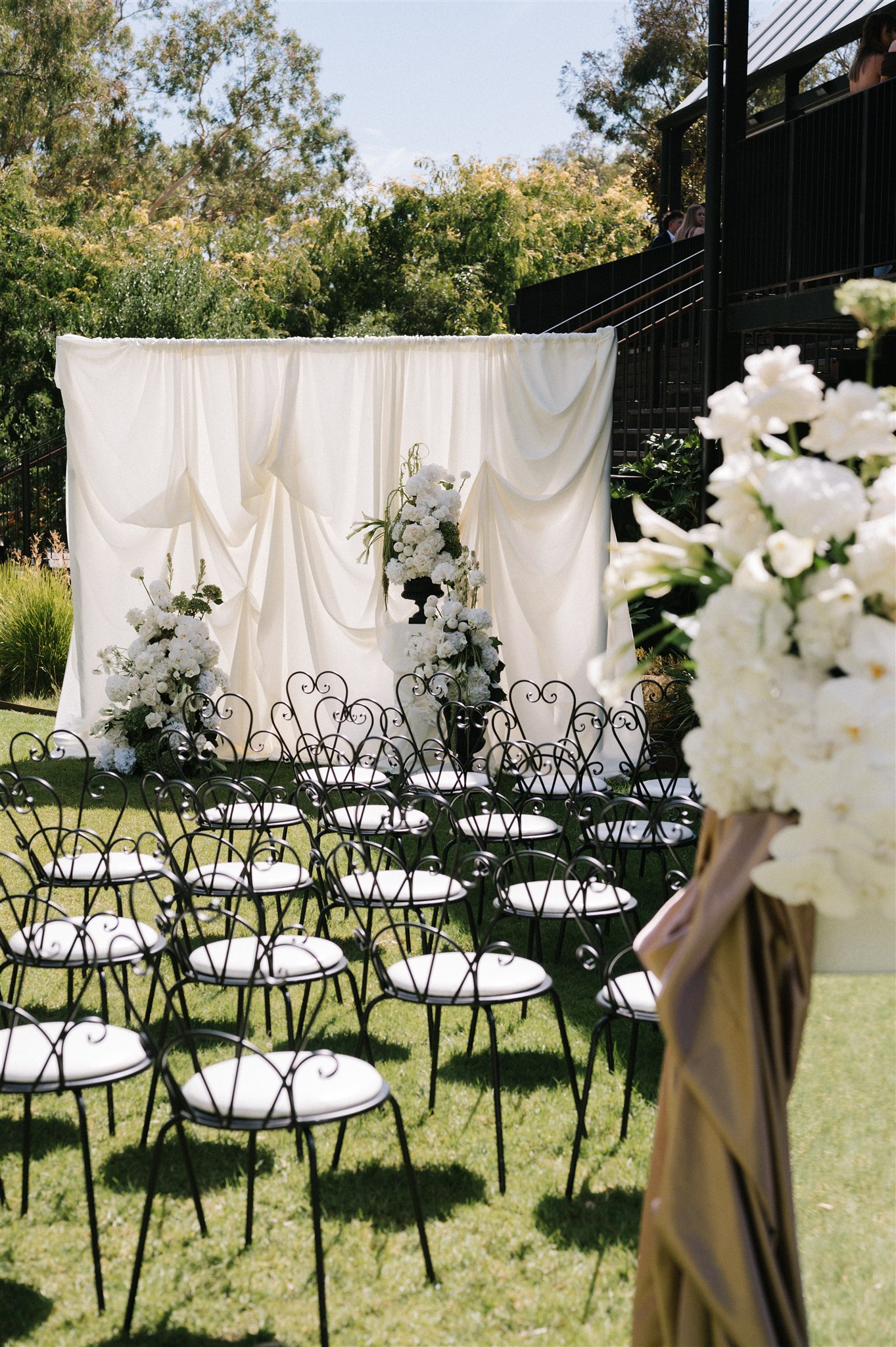 Wedding Arbor with draped luxurious white fabric and white and green florals at House on Haines