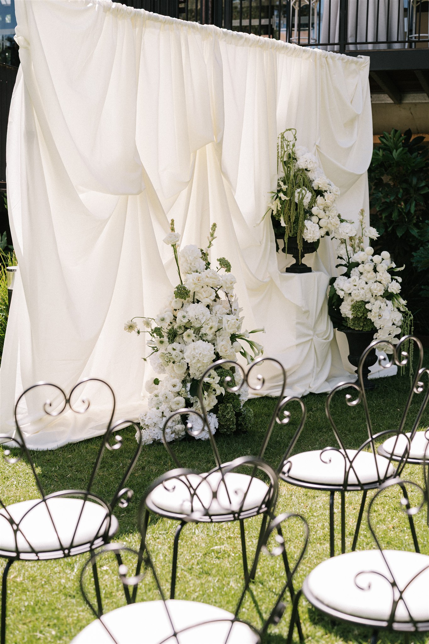 White wedding arbor layered in luxury fabric, classic black and white with white and green florals at House on Haines, Adelaide