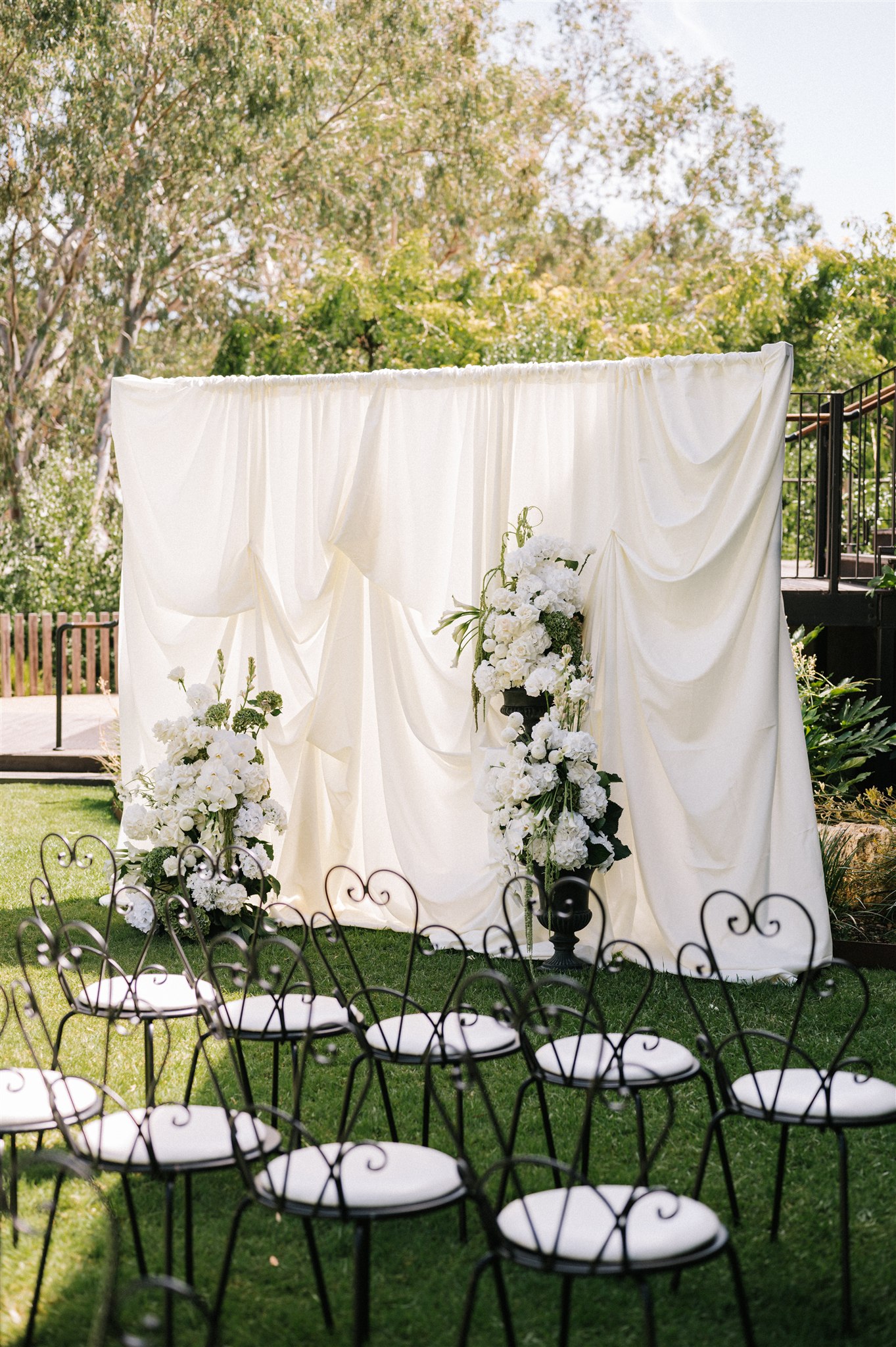 White wedding arbor layered in luxury fabric, classic black and white with white and green florals at House on Haines, Adelaide