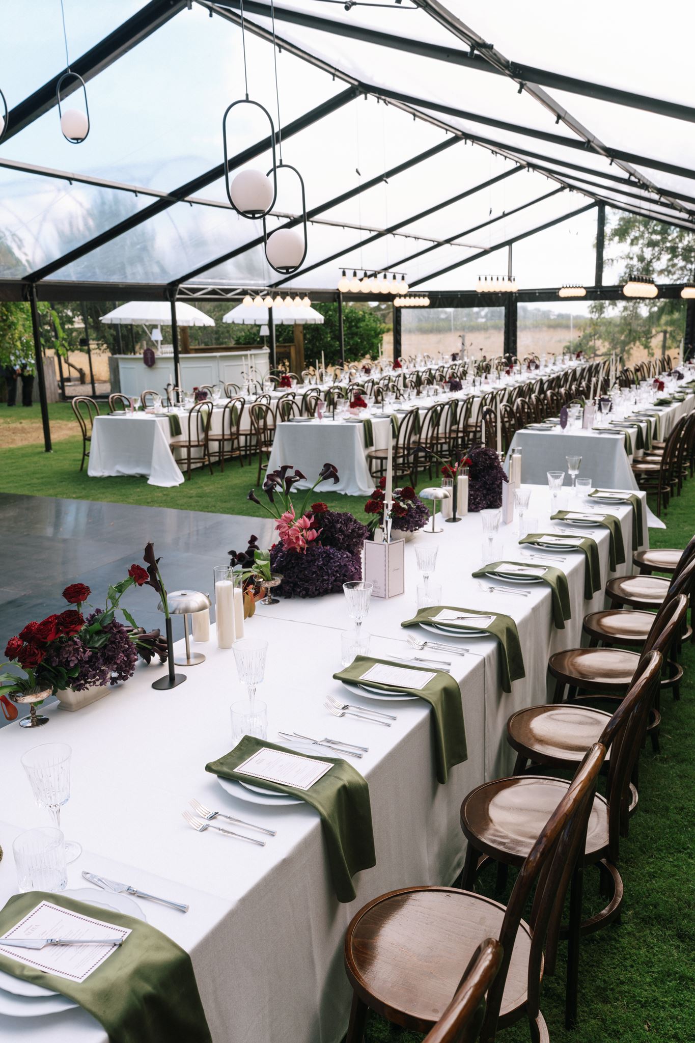 Long wedding reception tables inside clear marquee at Whites Valley Estate