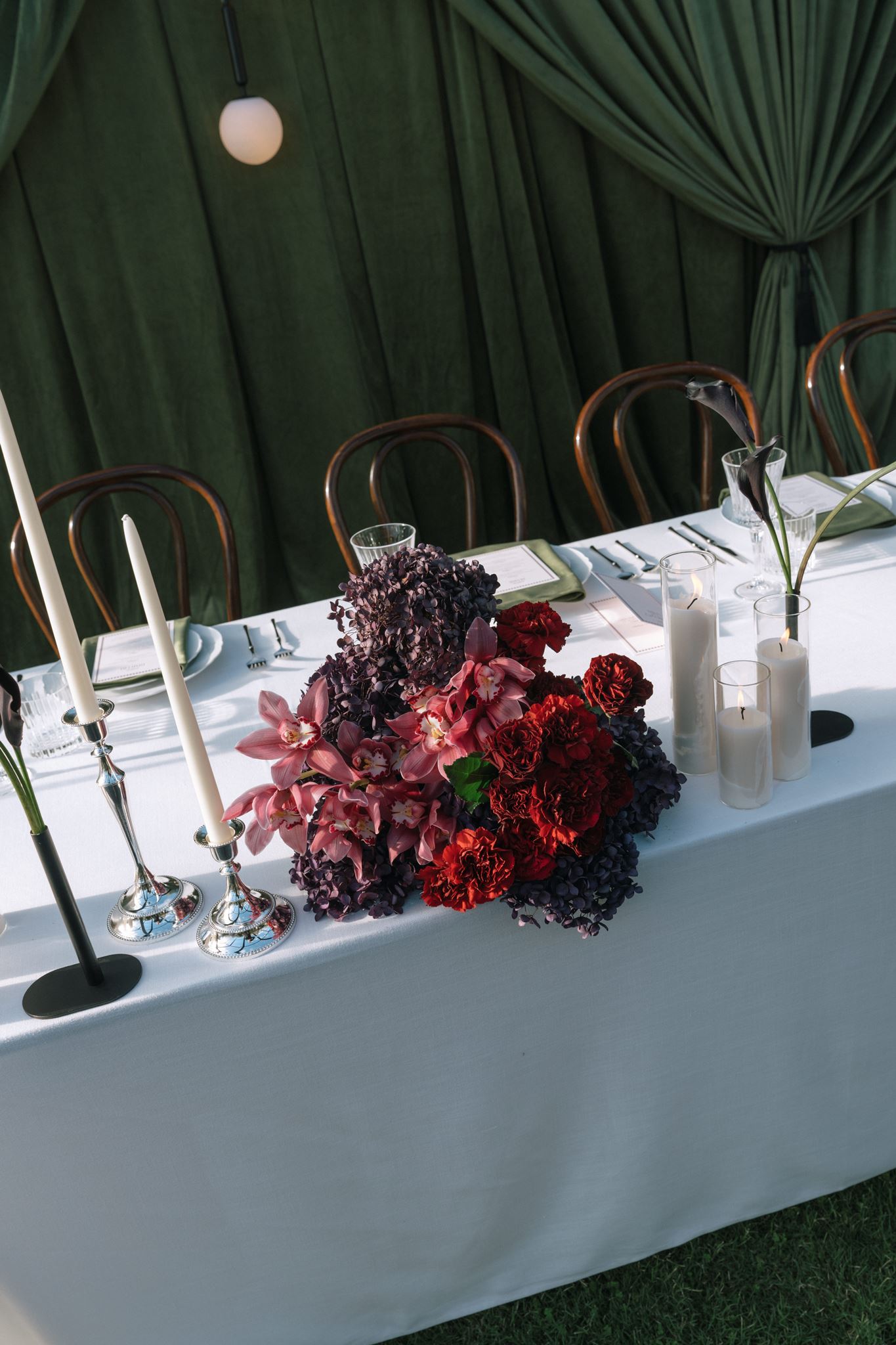 Bridal table with dark red and purple wedding floral display