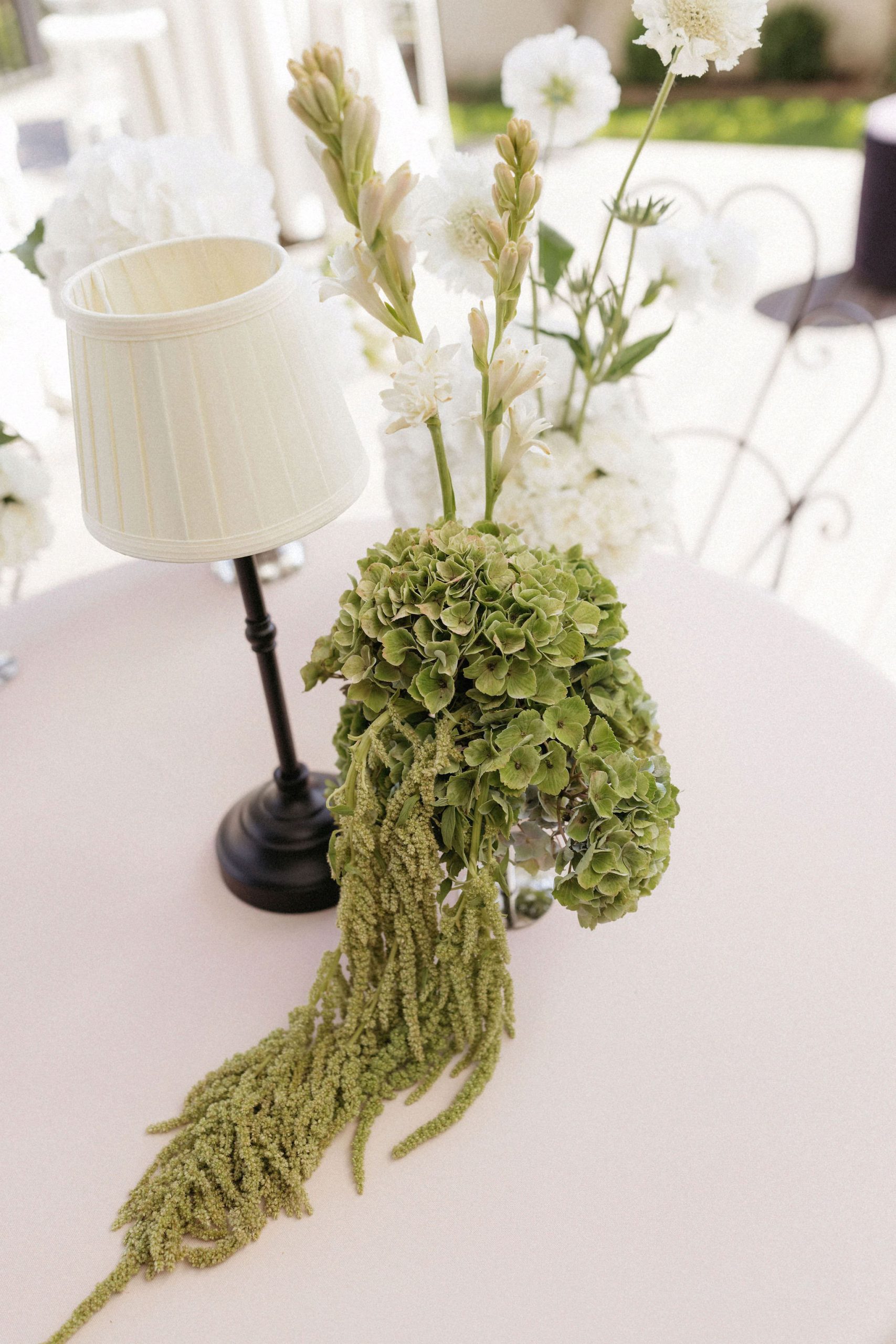 Draped green floral arrangement on table for wedding reception