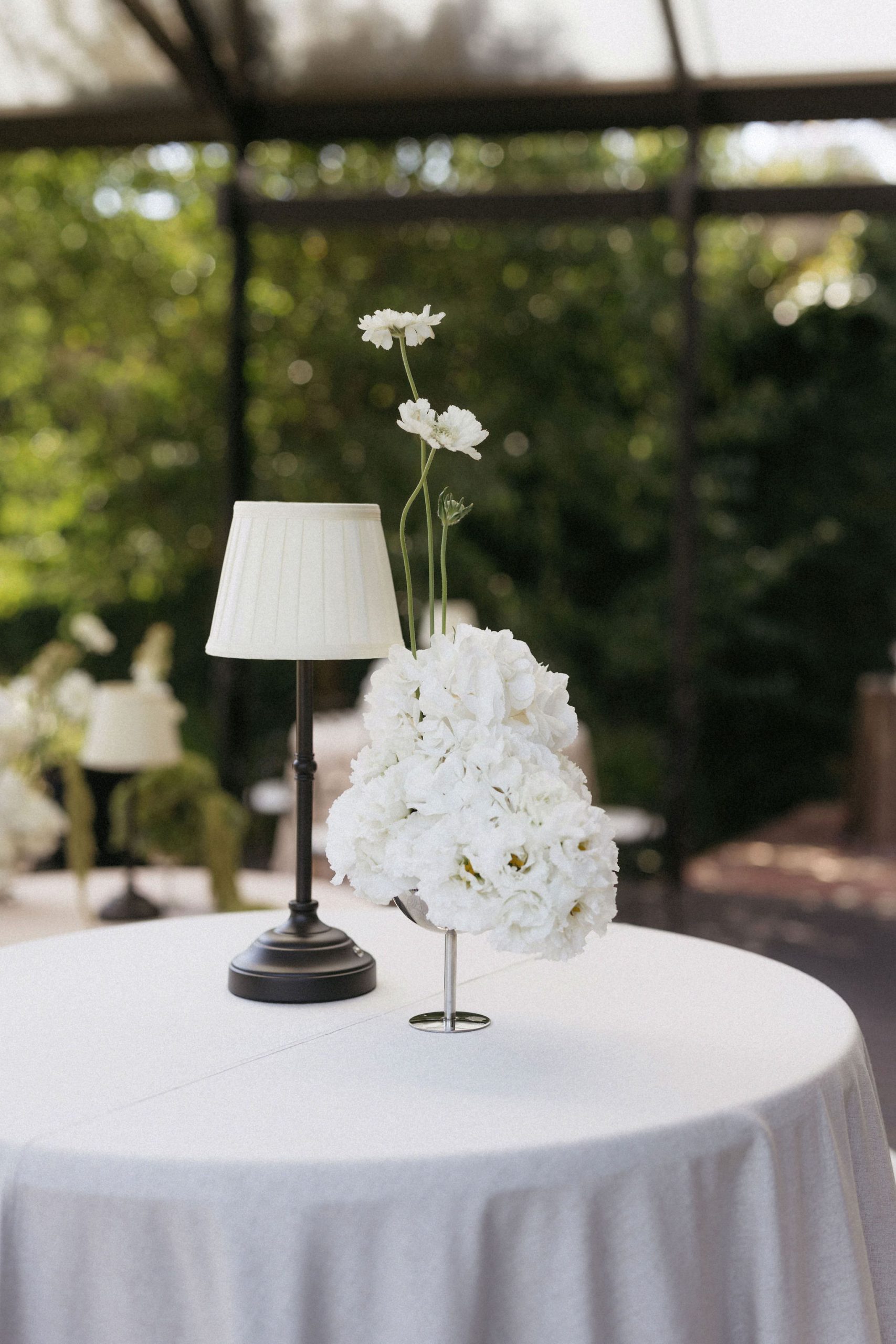 Lamp and white flowers on round table