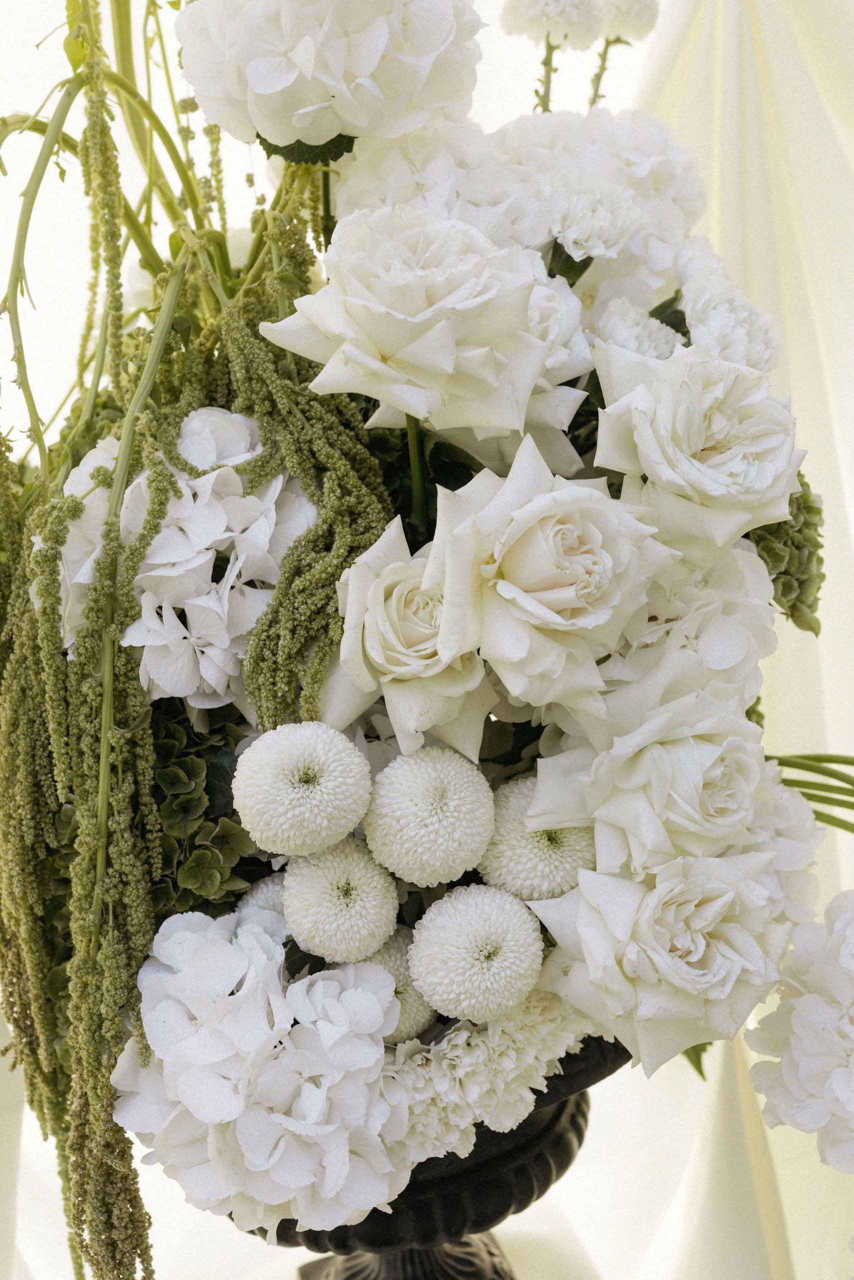 Large white and green floral arrangement with roses