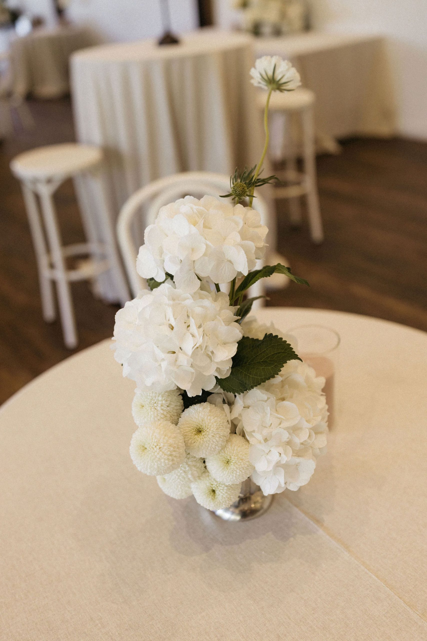 White floral arrangement on wedding reception round table