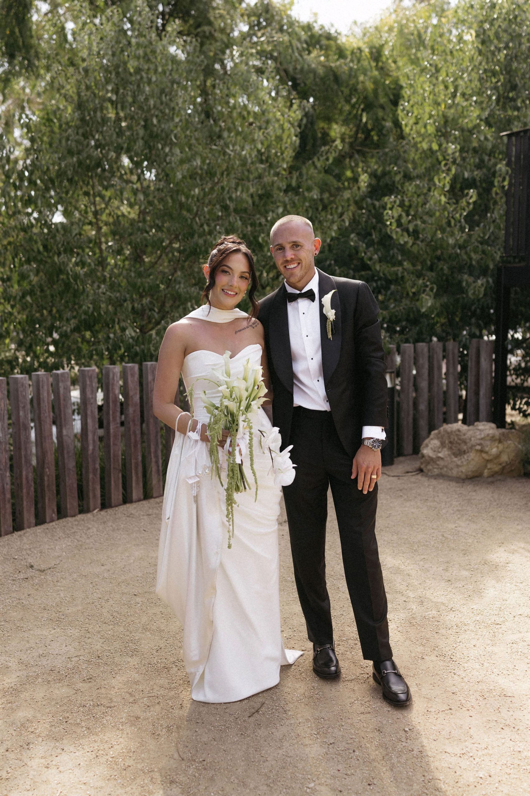 Bride wearing white love heart neckline wedding dress with groom in garden
