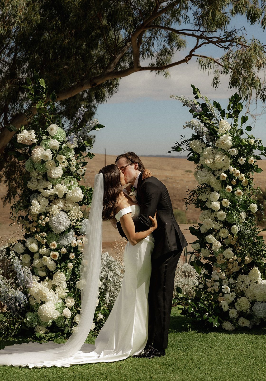 A dream wedding at Kingsford The Barossa featuring soft and elegant arbor florals in white, cream and buttery yellows