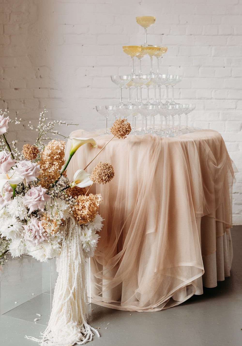 Champagne table with soft layering fabric and neutral rustic elegant modern flowers